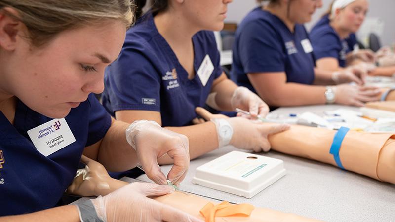 护理专业的学生正在练习给假手臂打针