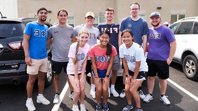 Fraternities Sororities members in shirts with logos for each